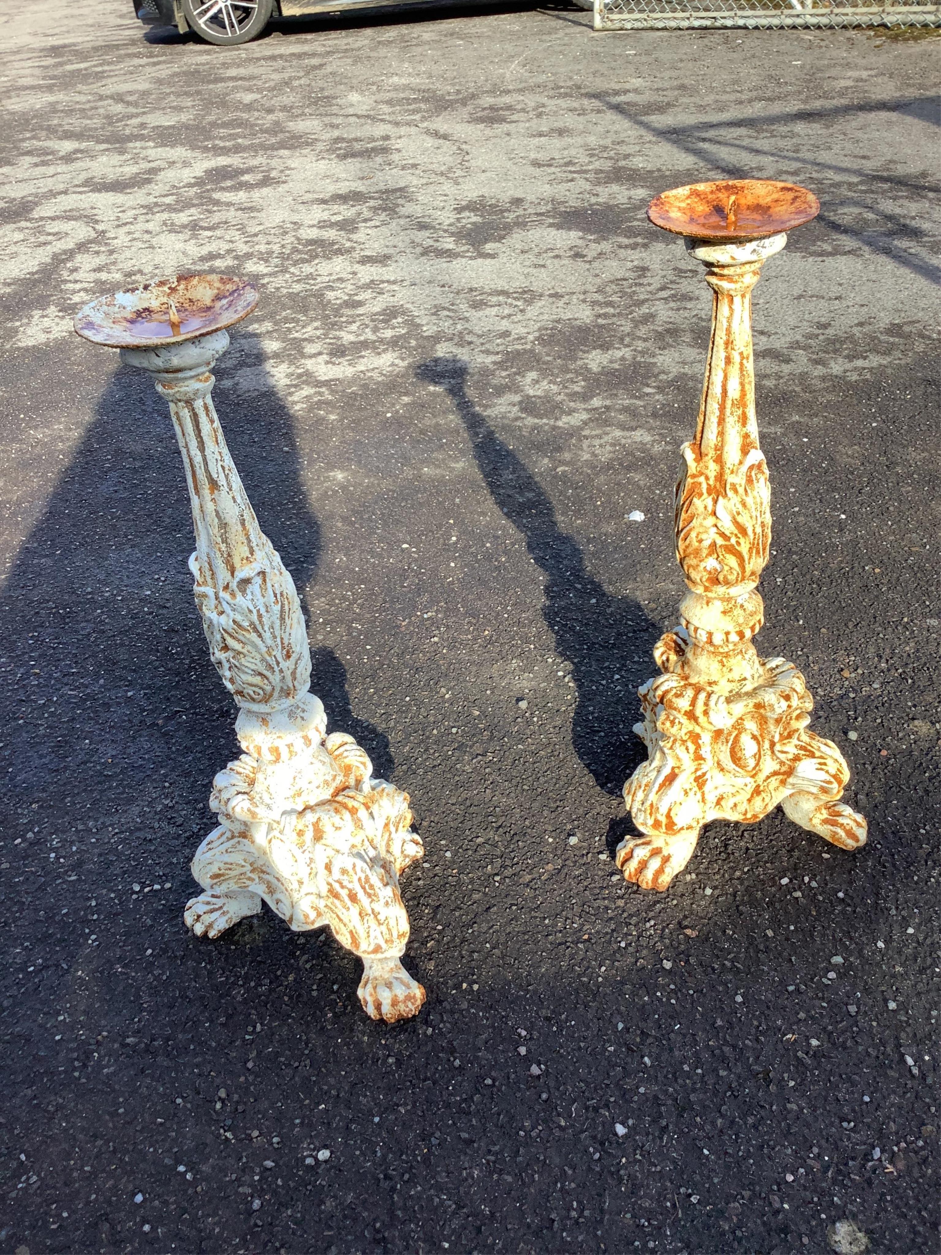 A pair of white painted cast iron pricket candlesticks, height 67cm. Condition - weathered